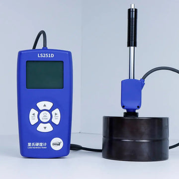 LS251D hardness tester displaying a measurement on its LCD screen, with the probe resting on a metal block.